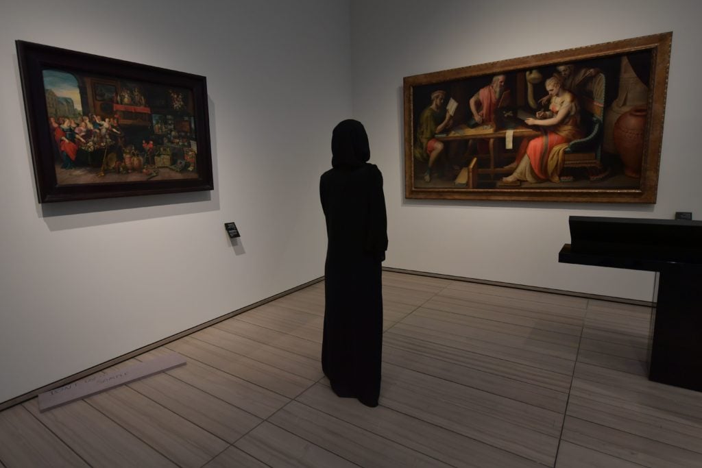 A woman looks at paintings at the Louvre Abu Dhabi Museum. (GIUSEPPE CACACE/AFP/Getty Images)