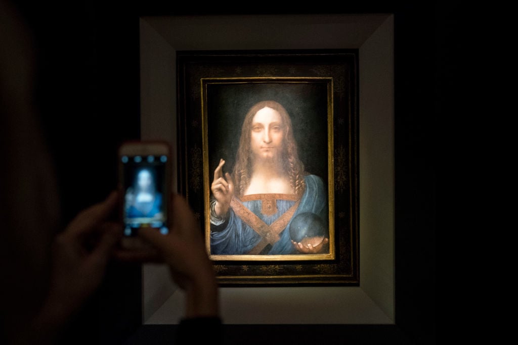 A visitor takes a photo of Leonardo's <i>Salvator Mundi</i> at Christie's New York. Drew Angerer/Getty Images.