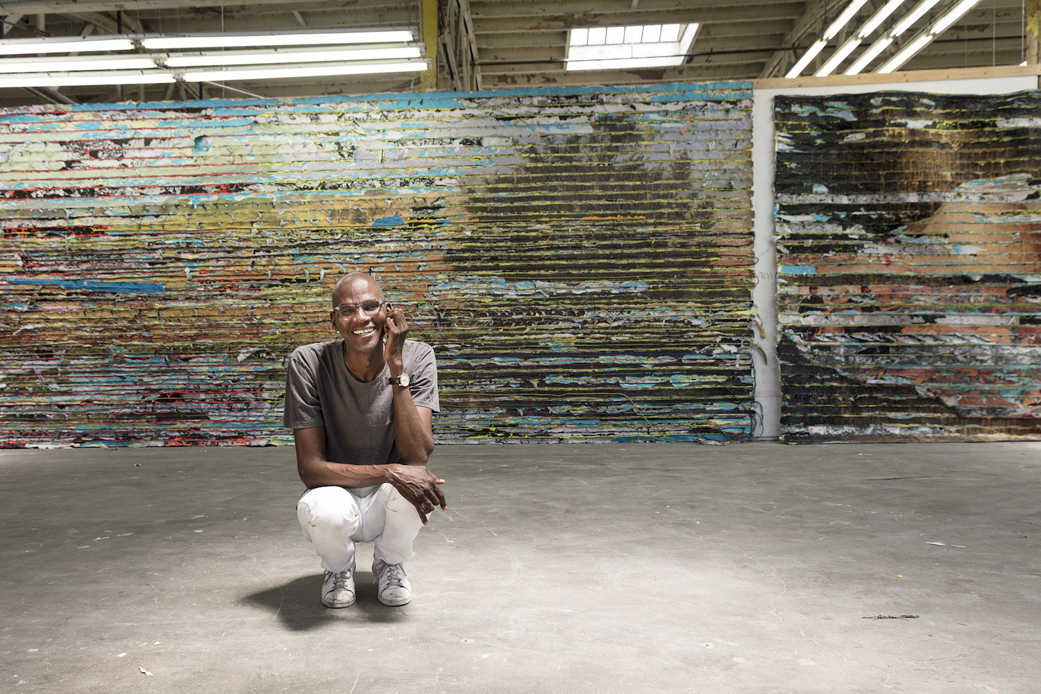 Mark Bradford, seen in his Los Angeles studio with a detail of Pickett's Charge (2017). Photo courtesy of the artist and Hauser & Wirth/photographer Agata Gravante.