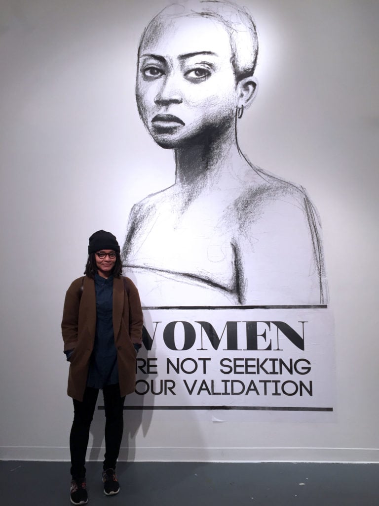 Tatyana Fazlalizadeh stands next to a piece from her street campaign 