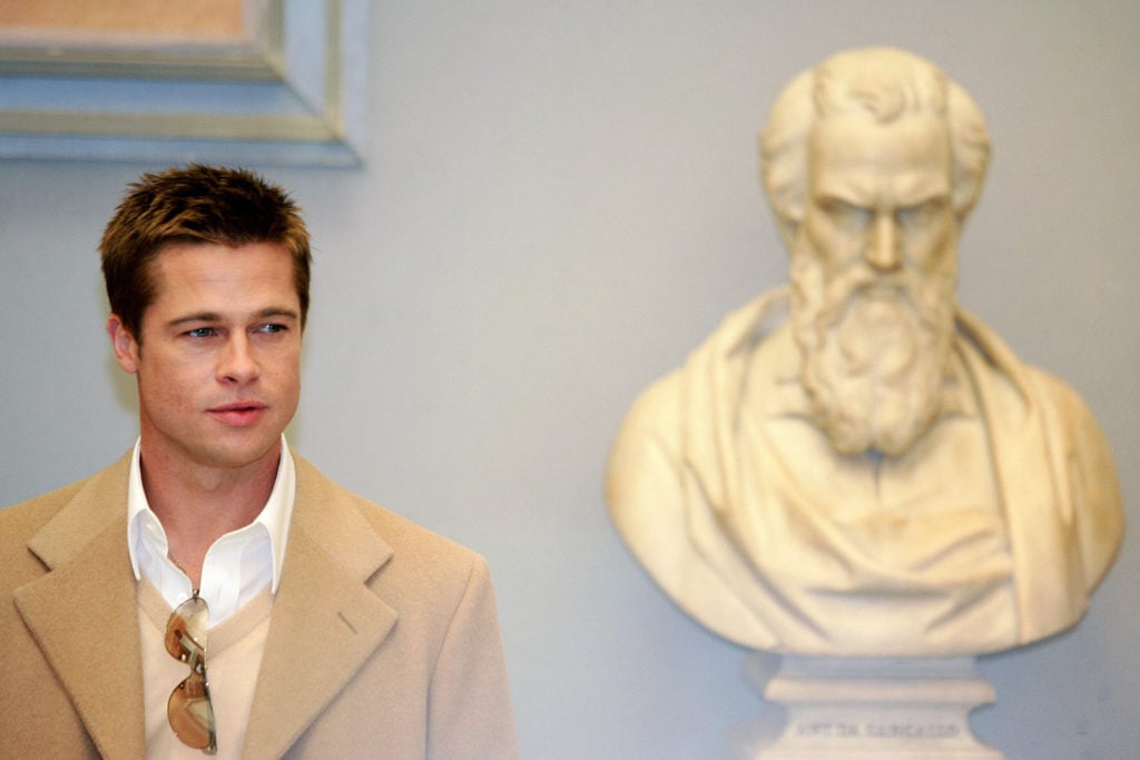 Brad Pitt posing with a sculpture in 2004. Photo courtesy of Patrick Hertzog/AFP/Getty Images.