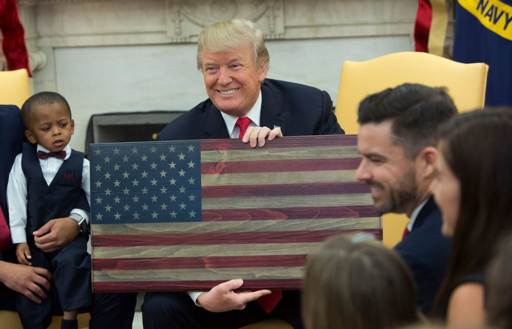 President Donald Trump holds a plaque made by Brian Steorts the owner of Flags of Valor on December 5, 2017 in Washington, DC. Photo by Chris Kleponis/Getty Images.