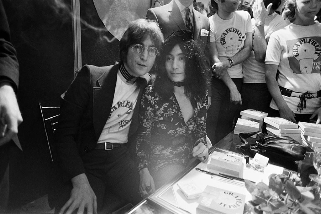 Singer and songwriterJohn Lennon with Yoko Ono, signing copies of her conceptual art book <em>Grapefruit</em> at Selfridges, London, 15th July 1971. Photo by Jack Kay/Daily Express/Getty Images.