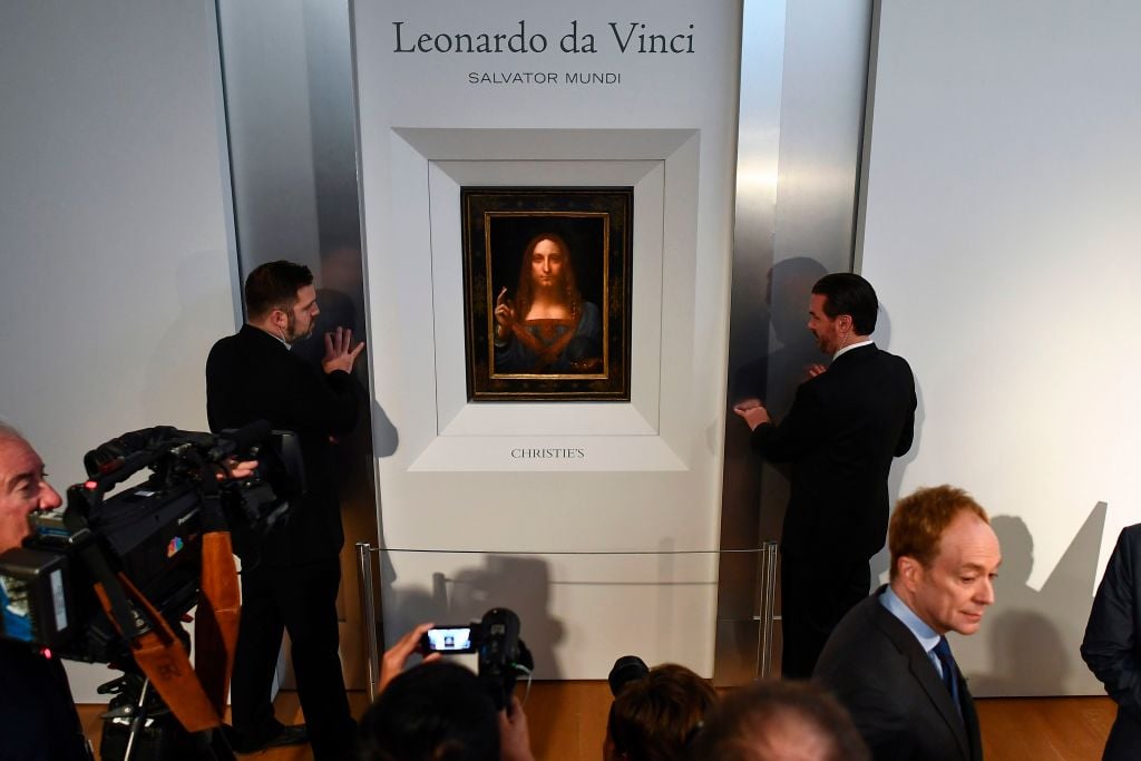 Security personnel stand next to Leonardo da Vinci's "Salvator Mundi" after it was unveiled at Christie's in New York on October 10, 2017. Photo credit should read Jewel Samad /AFP/Getty Images.