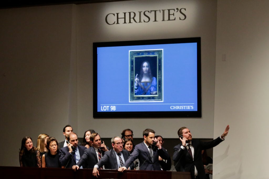 Agents speak on their phones with their clients while bidding on at the auction of Leonardo da Vinci's 