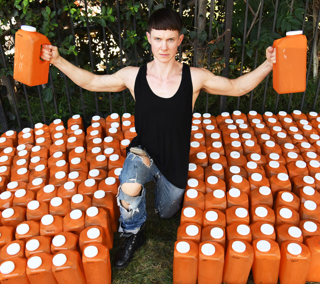 Artist Cassils, a 2018 United States Artists Fellow, and team collect bottles of urine from refrigerators across Los Angeles California, August 30, 3017, where they have been stored for consolidation in four 50 gallon drums for shipment to New York for Cassils' solo exhibition Monumental which will debut at Ronald Feldman Fine Arts in New York on September 16, 017. The centerpiece of the exhibition is PISSED , a minimalist glass cube containing 200 gallons of urine: a collection of all the liquid the artist has passed since the Trump administration rescinded an Obama-era executive order allowing transgender students to use the bathroom matching their chosen gender identities. Photo courtesy of Robin Beck.
