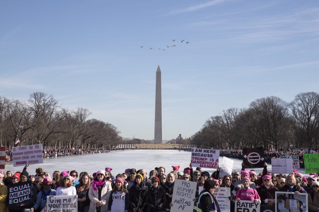 People gather at the Lincoln Memorial reflecting pool to rally before the Women's March on January 20, 2018 in Washington, DC. Photo courtesy of Alex Wroblewski/Getty Images.