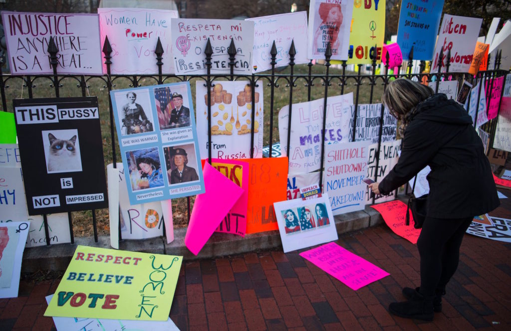 A women takes pictures of signs left in Lafayette Square after the Women's March on Washington 2018: March On The Polls! on January 20, 2018 in Washington, DC. Photo courtesy of Andrew Caballero-ReynoldsAFP/Getty Images.