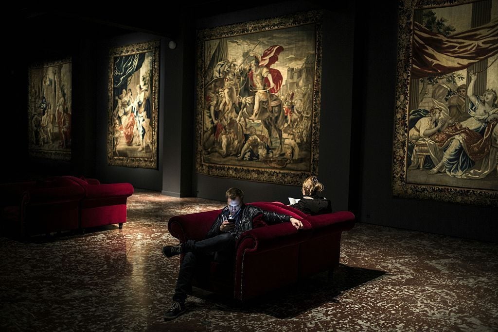 People look at a tapistry during their visit the Musee des Tissus (Museum of Textiles) in Lyon. Photo courtesy Jeff Pachoud/AFP/Getty Images.
