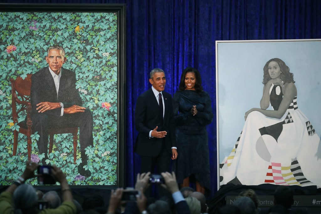 Former US President Barack Obama and former first lady Michelle Obama stand next to their newly unveiled portraits during a ceremony at the Smithsonian's National Portrait Gallery, on February 12, 2018 in Washington, DC. (Photo by Mark Wilson/Getty Images)