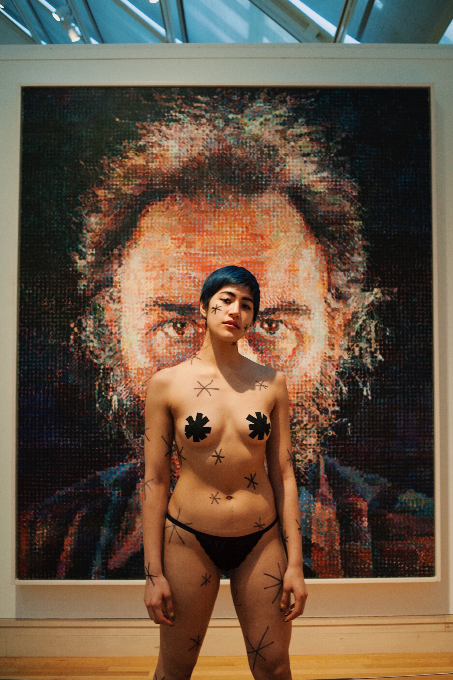 Emma Sulkowicz's protest performance, with a Chuck Close painting at t...