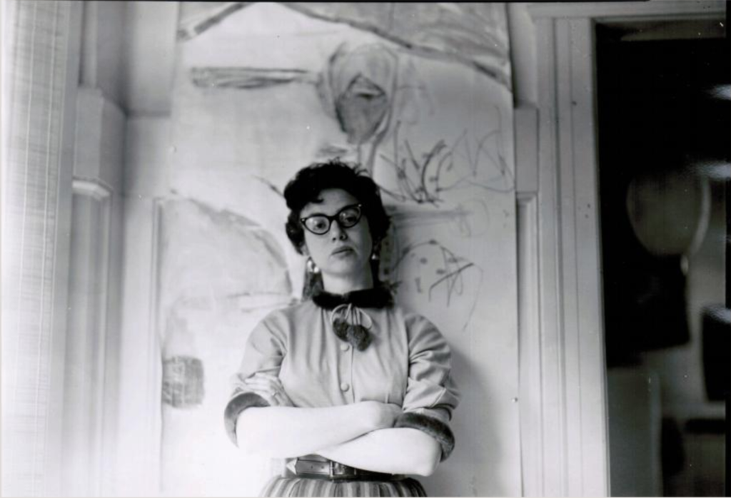 Sonia Gechtoff with a painting by her husband, James Kelley, at her Polk Street Studio in San Francisco (1954). Photo courtesy of the artist.