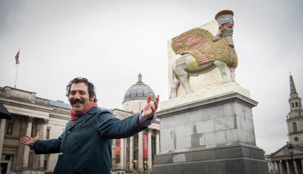 Michael Rakowitz in front of "The Invisible Enemy Should Not Exist" in Trafalgar Square. Photo by Caroline Teo.