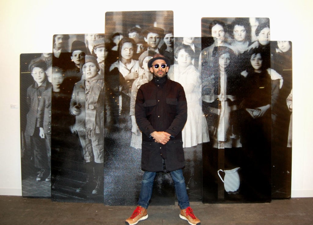 JR with his work, shown by Jeffrey Deitch, at the Armory Show. Photo courtesy of Sarah Cascone
