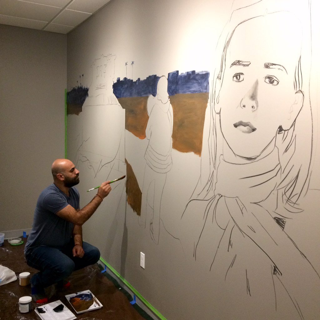 Ayed Arafah working on his mural of Rachel Corrie, an American-born pro-Palestinian activist killed by Israeli forces in 2003. Photo courtesy of the Palestine Museum US.