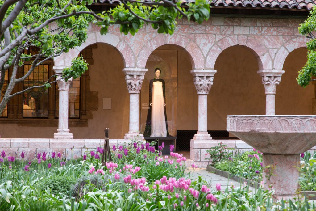 Installation view of "Heavenly Bodies" at the Cloisters, Cuxa Cloister. Photo courtesy of the Metropolitan Museum of Art.