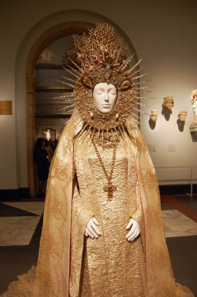 Yves Saint Laurent, Statuary Vestment for the Virgin of El Rocio, (circa 1985), on view in "Heavenly Bodies" at the Met Fifth Avenue, Medieval Sculpture Hall. On loan from Yves Saint Laurent. Photo by Sarah Cascone. 