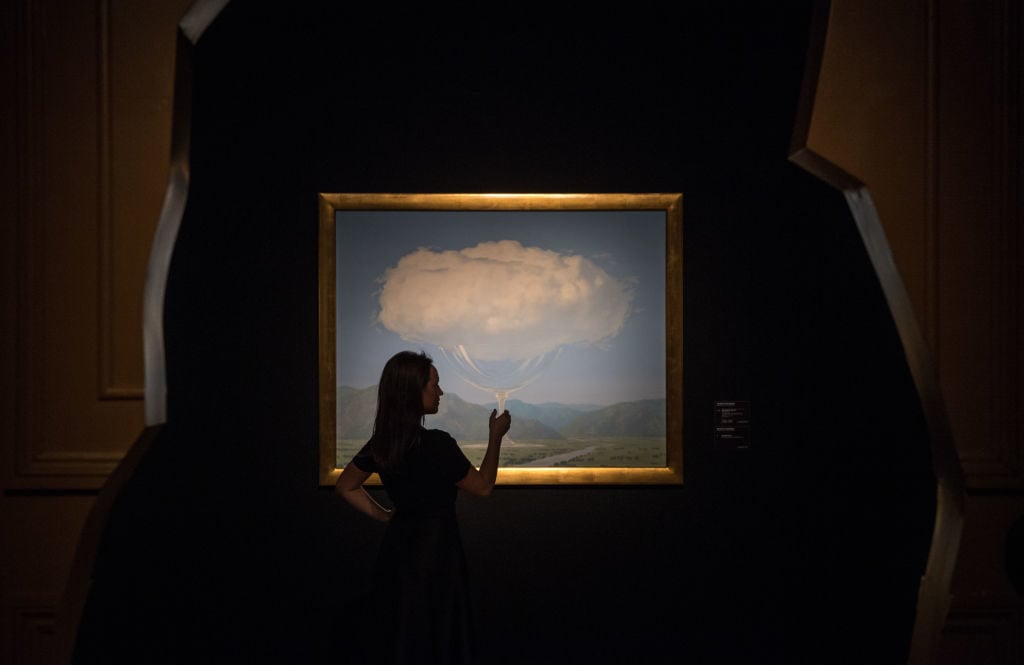 A woman poses for a photo in front of <em>La corde sensible</em> by Rene Magritte, estimated at Â£14-Â£18 million, at Christies on February 24, 2017 in London, England. 'The Art of the Surreal' sale will take place at Christies on 28 February, 2017. Photo by Chris J Ratcliffe/Getty Images.