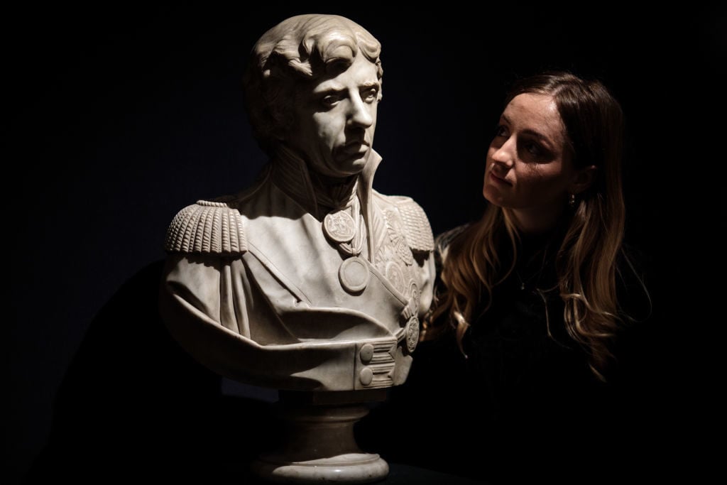 An employee poses with a marble bust of Lord Horatio Nelson, circa 1800 (est. Â£18,000-25,000) at Sotheby's on January 11, 2018 in London, England. Photo by Jack Taylor/Getty Images.
