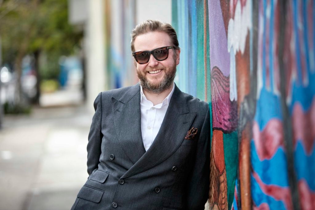 Ragnar Kjartansson in front of the MAESTRAPEACE Mural at the San Francisco Women's Building. Photo by Quinn Gravier.