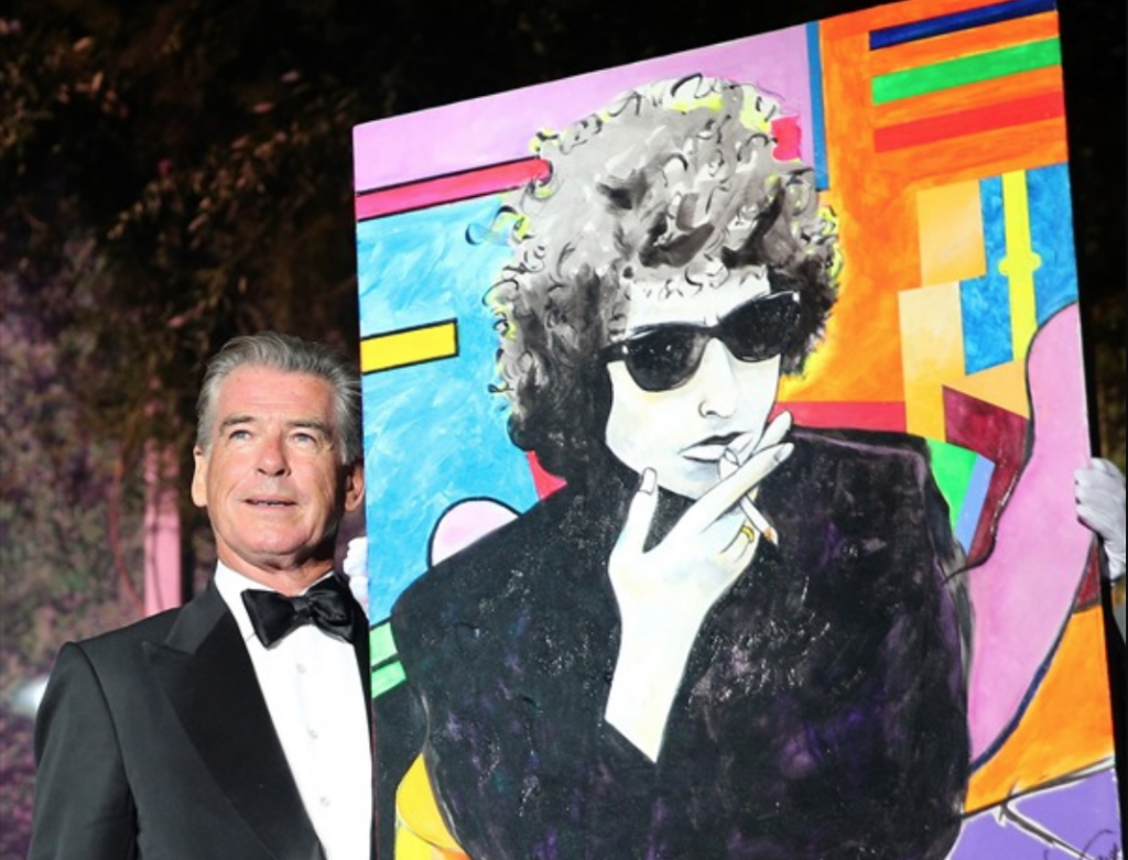 Pierce Brosnan with his $1.4 million painting of Bob Dylan. Photo courtesy of amFAR.