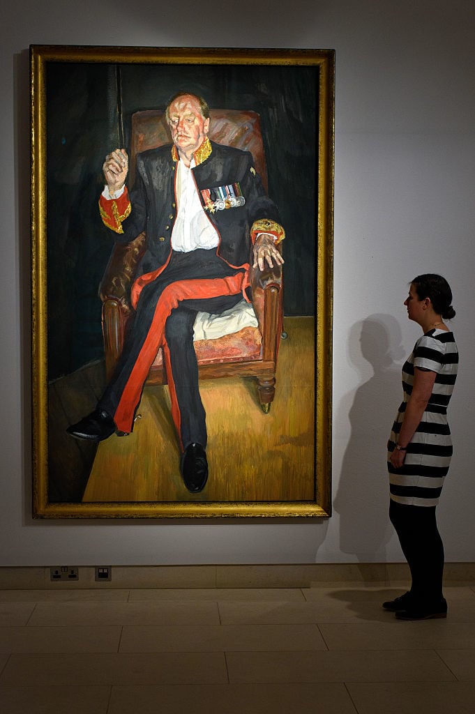 A gallery assistant views <em>The Brigadier</em> by artist Lucian Freud during the preview ahead of Christie's New York post war and contemporary art sale on October 9, 2015 in London, England. Photo by Ben Pruchnie/Getty Images.