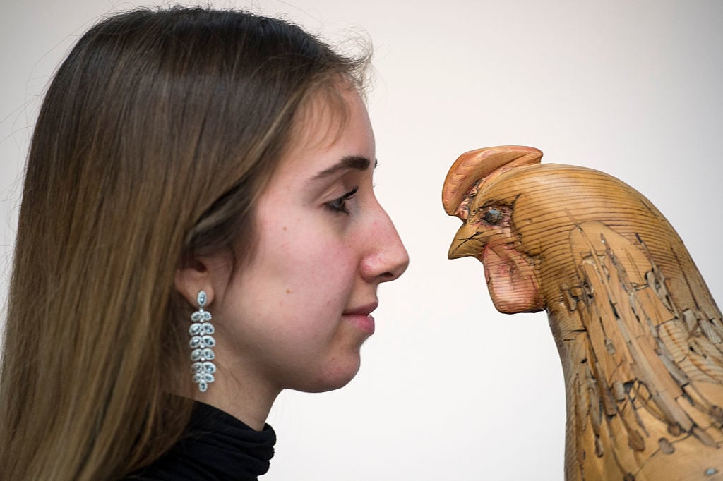 A Sotheby's employee stands next to a model of a hen by Nicholas Johnson during the pre-auction preview of the personal collection of Deborah Cavendish, Duchess of Devonshire at Sotheby's at Sotheby's on February 26, 2016 in London, England. Photo by Justin Setterfield/Getty Images.