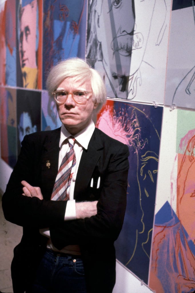 The American artist and filmmaker Andy Warhol with his paintings, December 15, 1980. Photo by Susan Greenwood/Liaison Agency.