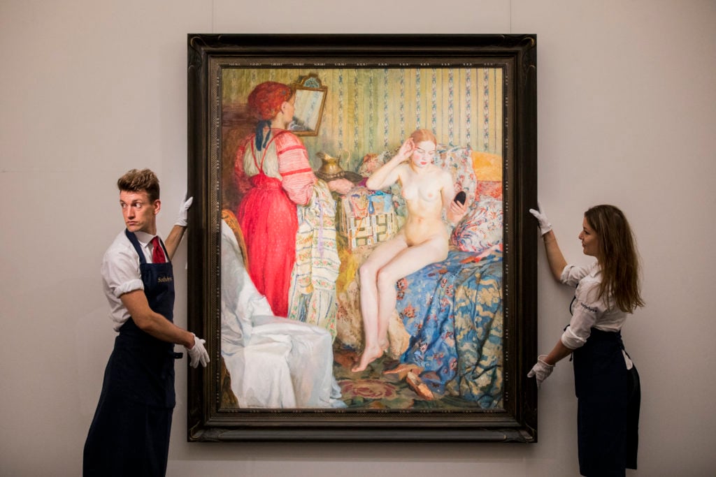 Two art handlers pose with Petr Iosifovich Smukrovich's <i>Toilette</i> on June 1, 2018 ahead of Sotheby's Russian art sales in London, England. (Photo by Tristan Fewings/Getty Images for Sotheby's)