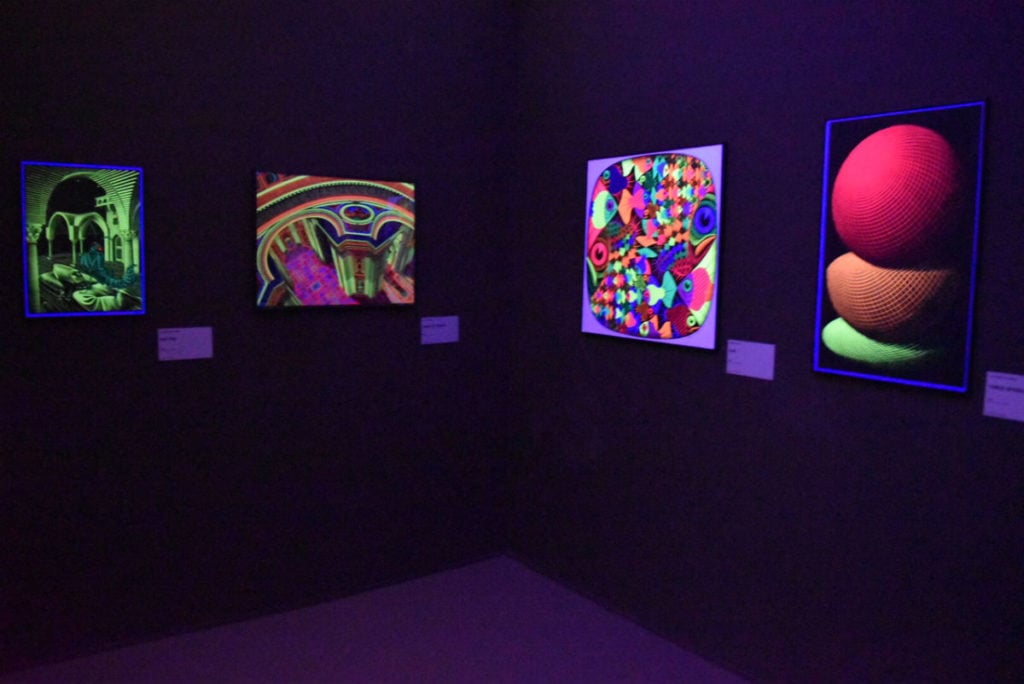 Selection of black light posters in "Escher: The Exhibition & Experience." Image courtesy Ben Davis.