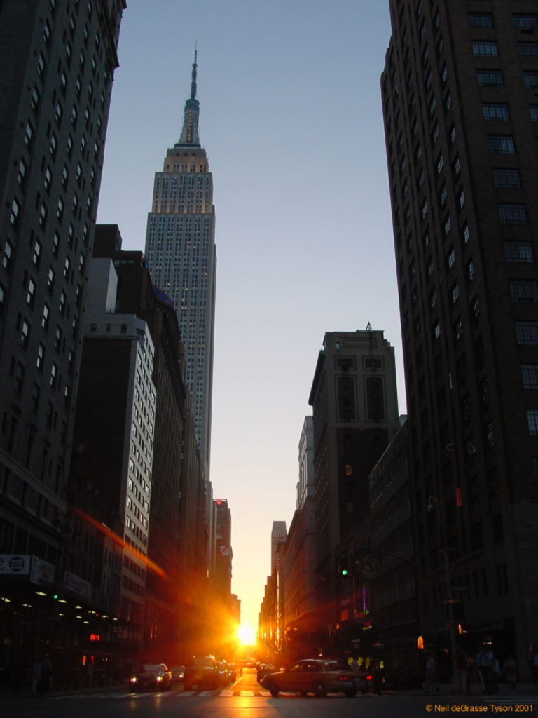 Neil deGrasse Tyson, Manhattanhenge (2001), sunset looking down 34th Street. One of two days when the sunset is exactly aligned with the grid of streets in Manhattan. Photo ©Neil deGrasse Tyson, courtesy of the American Museum of Natural History.