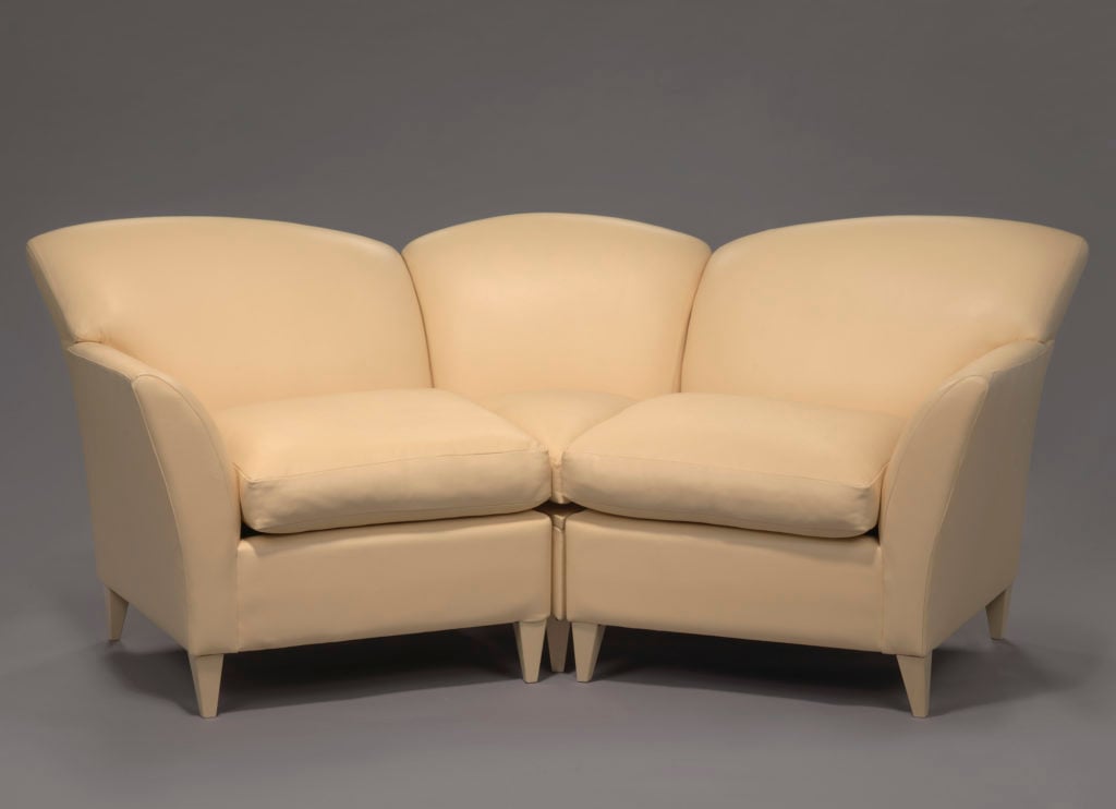 A sectional leather couch or sofa used on <em>The Oprah Winfrey Show</em>. The couch is upholstered in a light yellow leather. The couch curves in a semi-circular shape. The left and the right sections are for sitting, while the center section is topped with a table top on which Winfrey and her guests could place cups and other items. Photo courtesy of the National Museum of African American History and Culture.