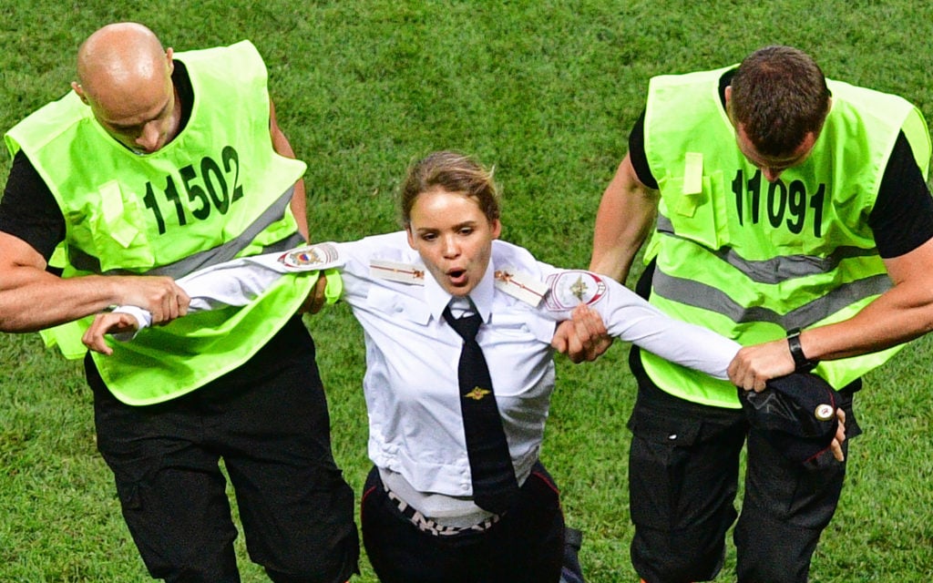 Veronica Nikulshina, a member of the Russian protest-art group Pussy Riot, is escorted off the pitch after staging an on-field protest during the Russia 2018 World Cup final football match between France and Croatia at the Luzhniki Stadium in Moscow on July 15, 2018. Photo by Mladen Antonov/AFP/Getty Images.