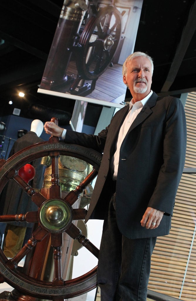 Canadian film director James Cameron poses next to a ships wheel from the film 'Titanic' as he visits the Titanic Belfast Museum in Belfast, Northern Ireland, on September 7, 2012. Cameron, director of the Oscar nominated film 'Titanic', and producer John Landau opened the first exhibit Friday dedicated to the film at the world's largest Titanic museum, featuring props and costumes from Cameron's personal collection. Photo by Peter Muhly/AFP/GettyImages)