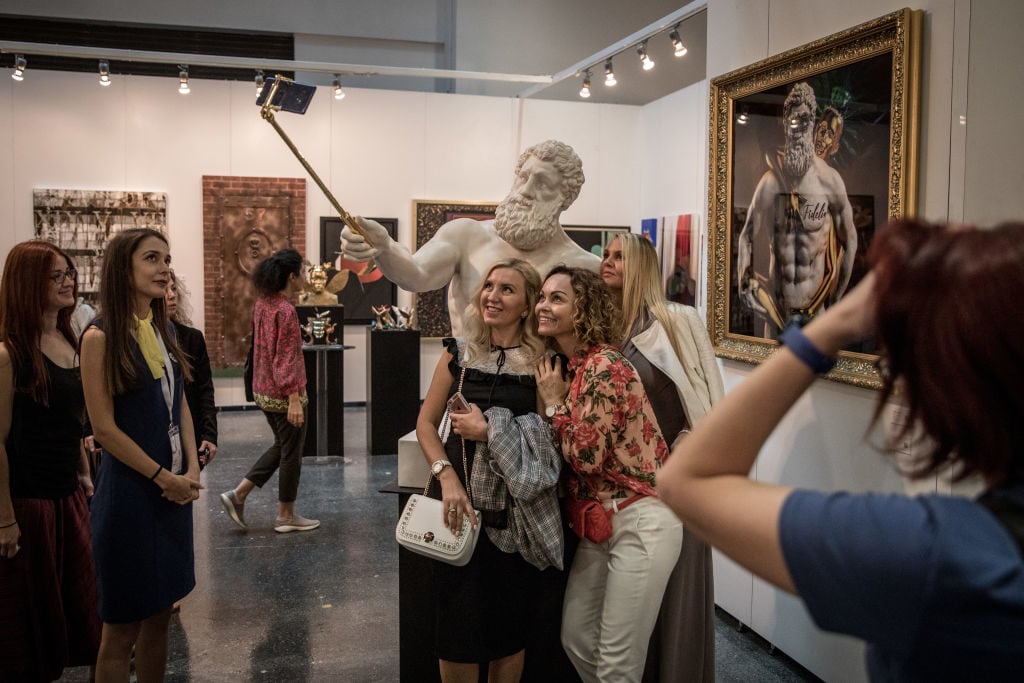 People pose for a selfie with <em>Hercules Selfie</em> an artwork by Emre Yusufi on display at Contemporary Istanbul on September 20, 2018 in Istanbul, Turkey. Photo by Chris McGrath/Getty Images.