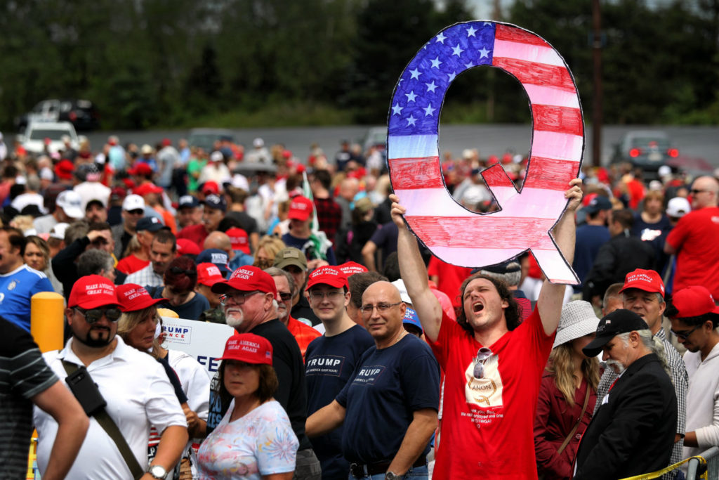 A man holds a large "Q" sign while waiting in line on August 2, 2018 at the Mohegan Sun Arena at Casey Plaza in Wilkes Barre, Pennsylvania to see President Donald J. Trump at his rally. Photo by Rick Loomis/Getty Images.