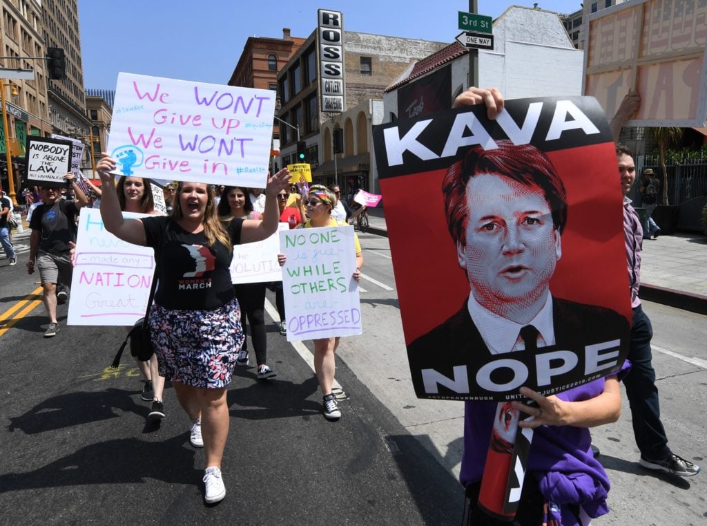 Tracie Ching's <em>Kavanope</em> poster at the "Unite for Justice" rally protesting the Supreme Court nomination of Brett Kavanaugh, in Los Angeles on August 26. 2018. Photo by Mark Ralston/AFP/Getty. 