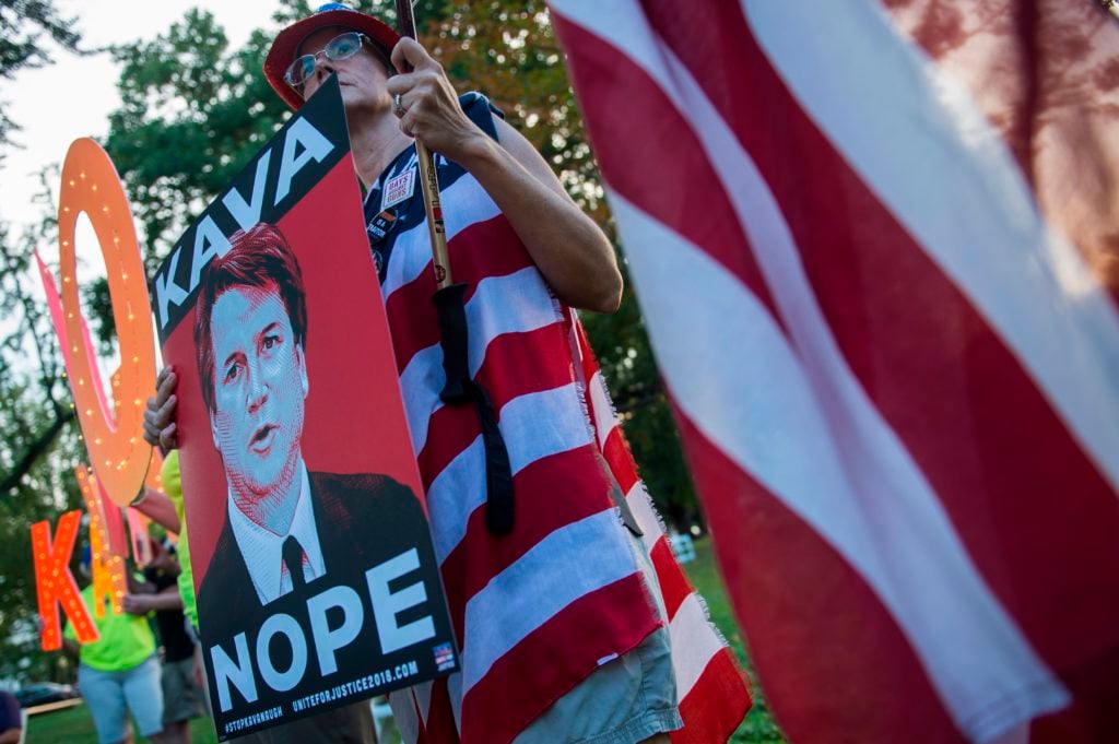 Protesters hold up signs, including Tracie Ching's <em>Kavanope</em> poster, during a rally near Capitol Hill against the confirmation hearing for Judge Brett Kavanaugh to be an Associate Justice on the US Supreme Court in Washington, DC, on September 4, 2018. Photo by Andrew Caballero-Reynolds/AFP/Getty Images.
