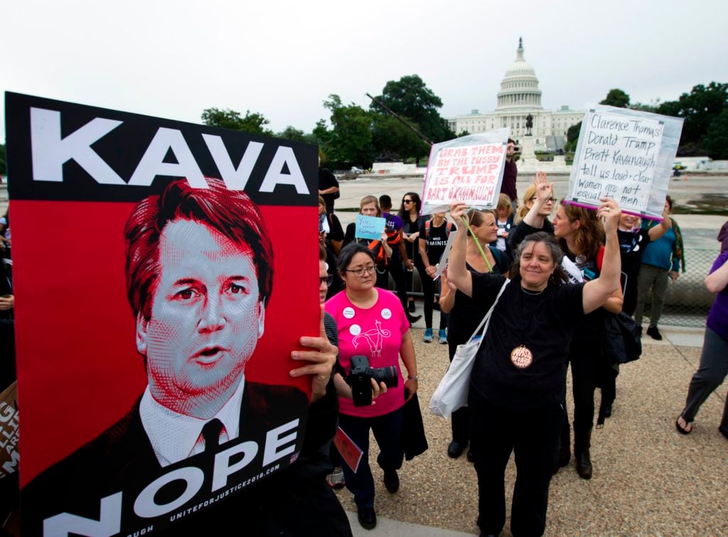 Demonstrators with Tracie Ching's <em>Kavanope</em> poster protest against the appointment of Supreme Court nominee Brett Kavanaugh on the streets outside on Capitol Hill in Washington DC, on September 27, 2018. Photo by Jose Luis Magana/AFP/Getty Images.