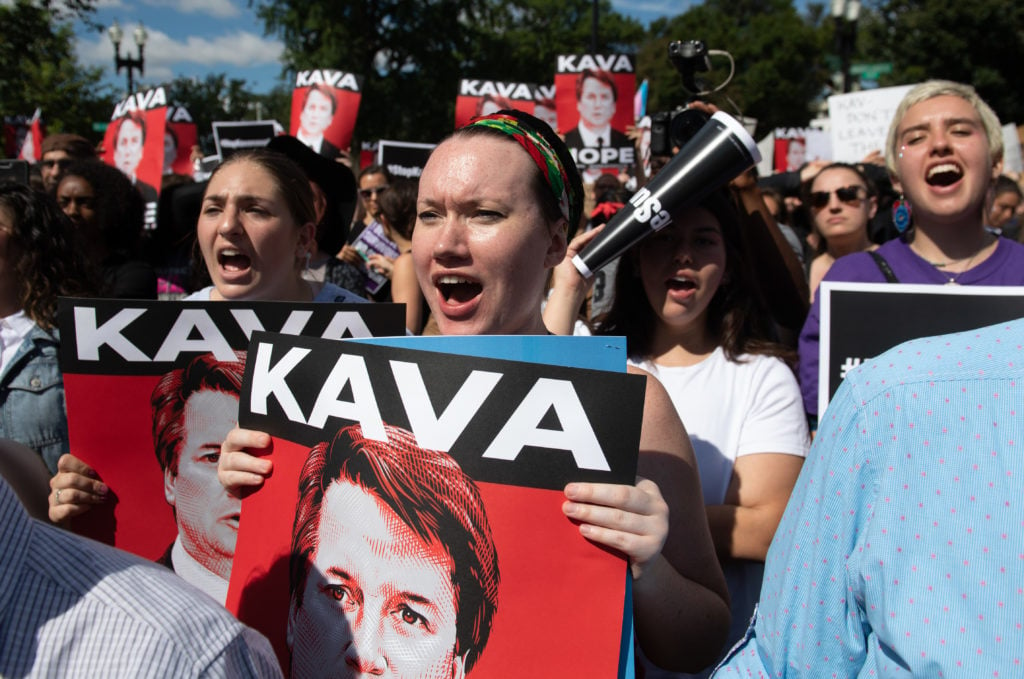 Demonstrators protesting against Judge Brett Kavanaugh's nomination as an Associate Justice on the Supreme Court hold a rally outside the US Supreme Court in Washington, DC, September 28, 2018. Many hold Tracie Ching's <em>Kavanope</em> poster. Photo by Saul Loeb/AFP/Getty Images.