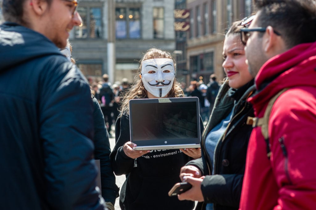 An activist wearing a Guy Fawkes mask, favored by the notorious hacker network known as Anonymous, during a demonstration in Amsterdam, the Netherlands. (Photo by Ana Fernandez/SOPA Images/LightRocket via Getty Images)