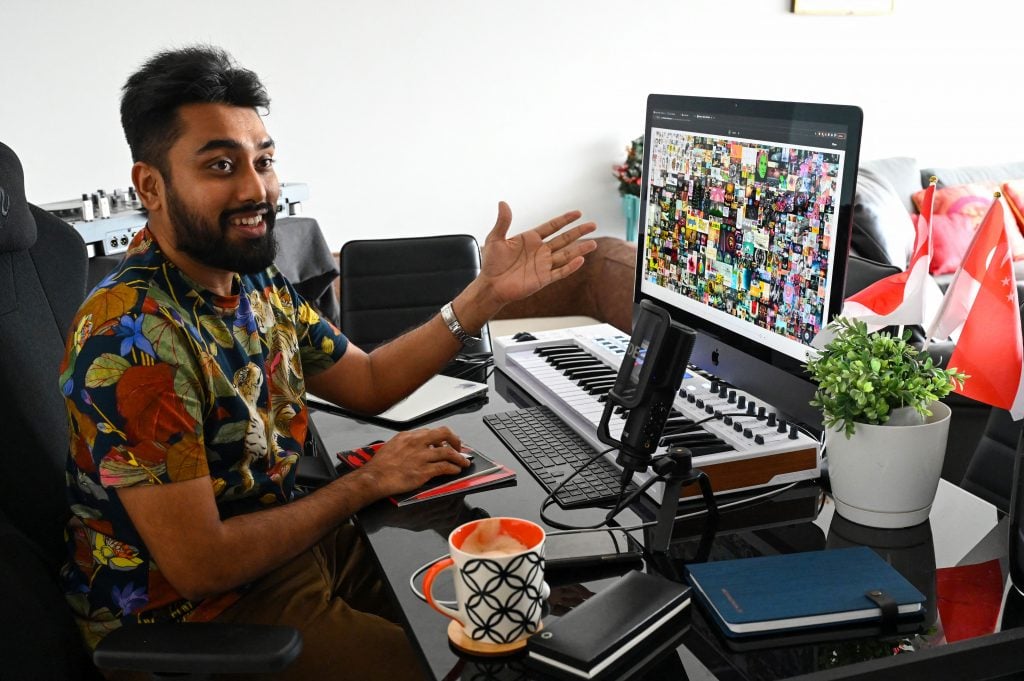 Blockchain entrepreneur Vignesh Sundaresan (AKA Metakovan) showing off Beeple's Everydays: The First 5,000 Days (2021) in his home in Singapore for an interview with Catherine Lai on April 7, 2021. (Photo by Roslan Rahman / AFP via Getty Images)