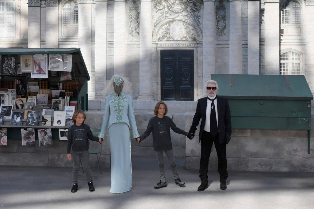 German fashion designer Karl Lagerfeld acknowledges the audience at the end of the Chanel 2018–19 Fall/Winter Haute Couture collection fashion show, in front of a replica of the front entrance of the French Institute at the Grand Palais in Paris, on July 3, 2018. Photo credit should read Alain Jocard/AFP/Getty Images.