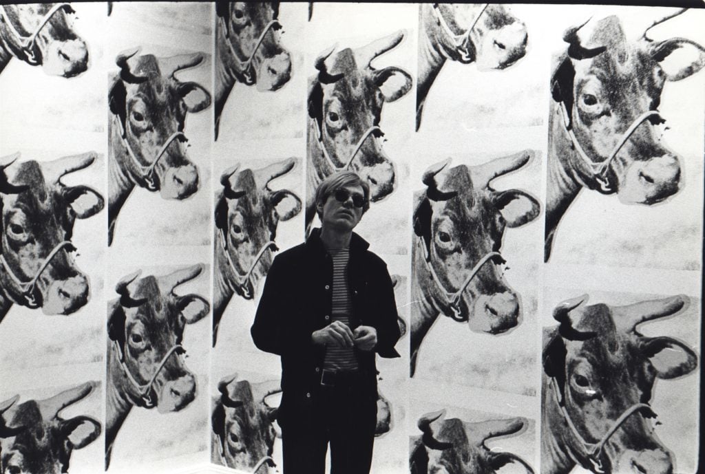 Andy Warhol with his Cow wallpaper at Leo Castelli (1966). Photo by Fred W. McDarrah, courtesy of Steven Kasher Gallery.