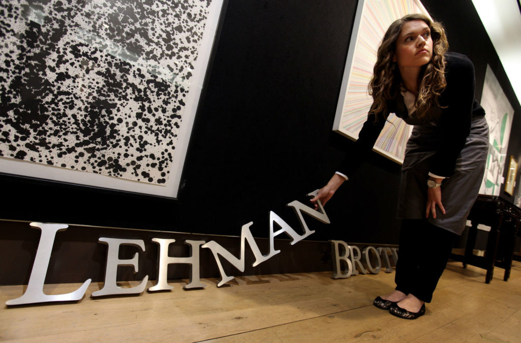 An employee of Christie's auction house manoeuvres a Lehman Brothers corporate logo for the 
