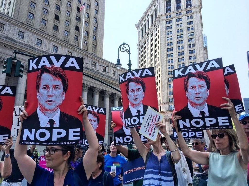 Demonstrators with Tracie Ching's Kavanope poster (2018). Photo courtesy of the artist.