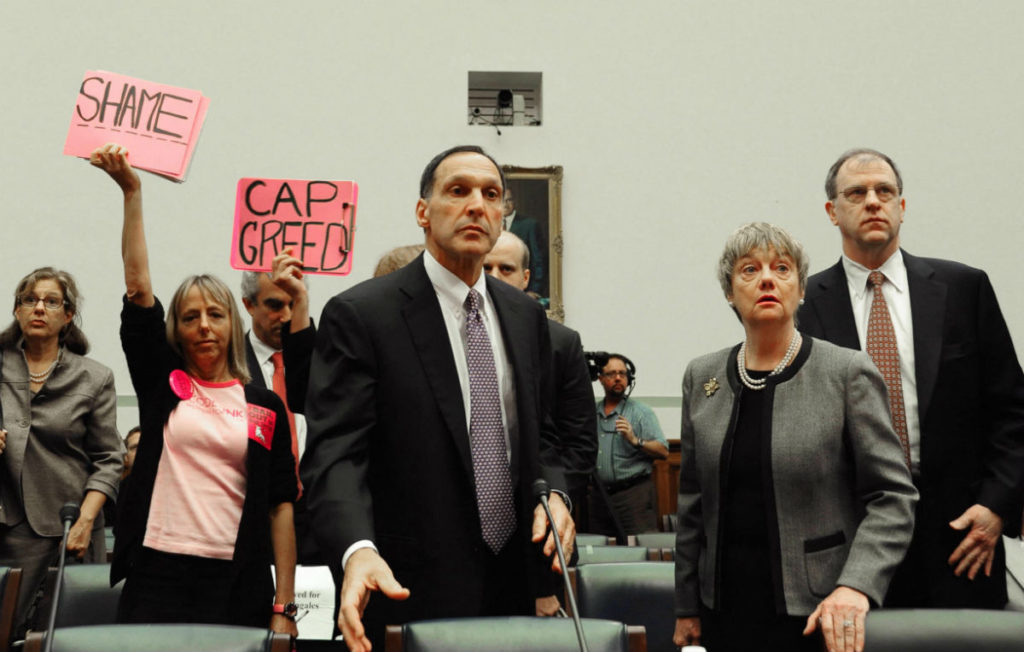 Members of the group Code Pink wave signs as Richard S. Fuld Jr. arrives to testify before the US House Oversight and Government Reform Committee October 6, 2008 on Capitol Hill in Washington, DC. Photo courtesy Karen Bleier/AFP/Getty Images.