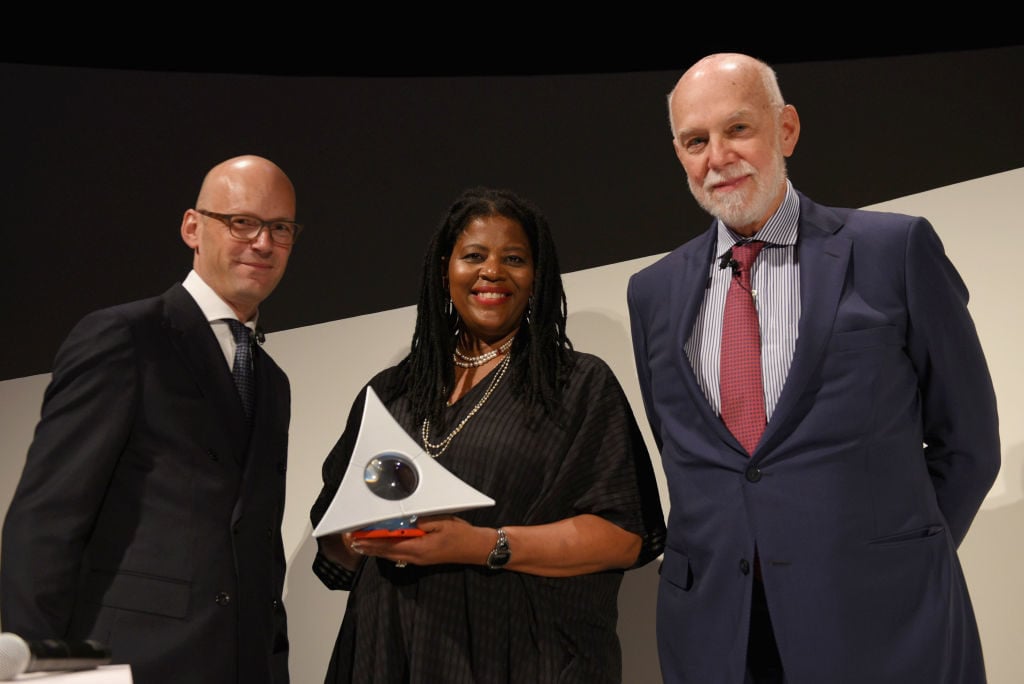 Hugo Boss CEO Mark Langer, artist Simone Leigh, and former Solomon R. Guggenheim Museum director Richard Armstrong onstage at the Hugo Boss Prize 2018 Artists Dinner at the Guggenheim Museum. Photo by Andrew Toth/Getty Images for Hugo Boss Prize 2018.