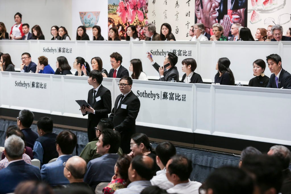 Sotheby's staff take phone bids during an auction at Sotheby's in Hong Kong on April 3, 2018. Photo credit: Isaac Lawrence/AFP/Getty Images.