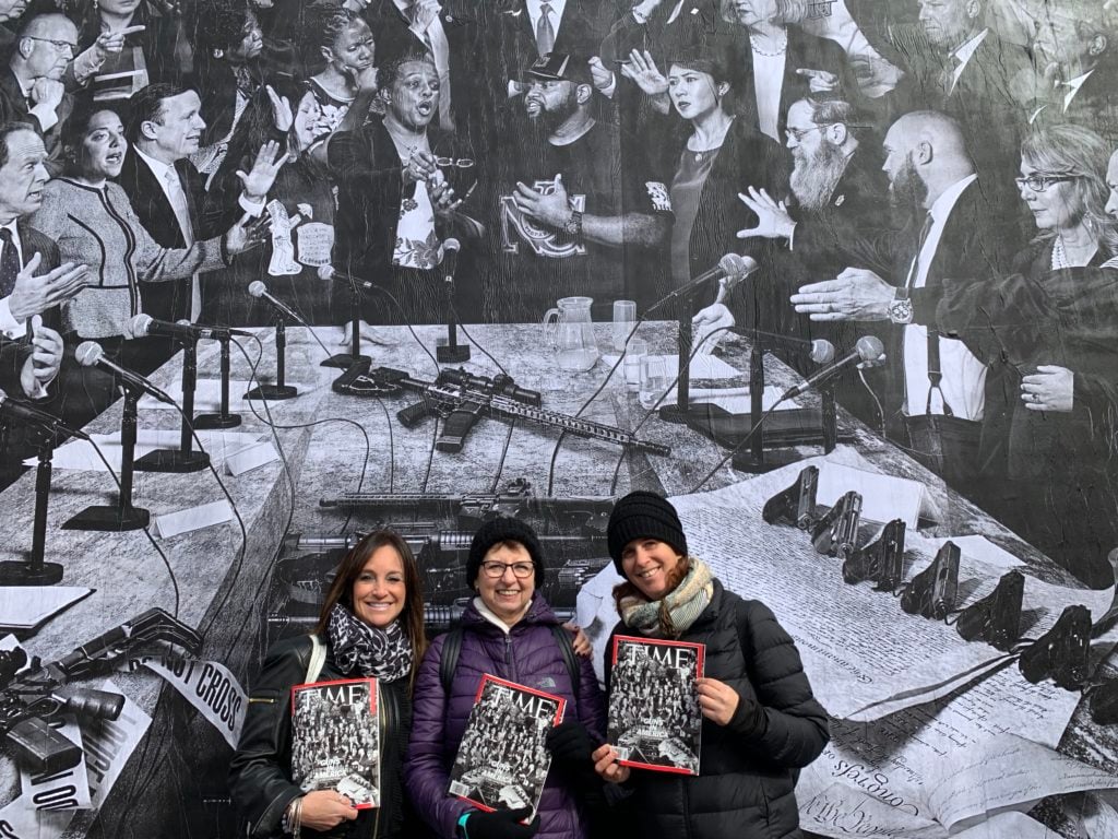 Cari Elpren, Helene Landau, and Dana Landau with JR's "Guns in America" mural. Photo by Sarah Cascone.